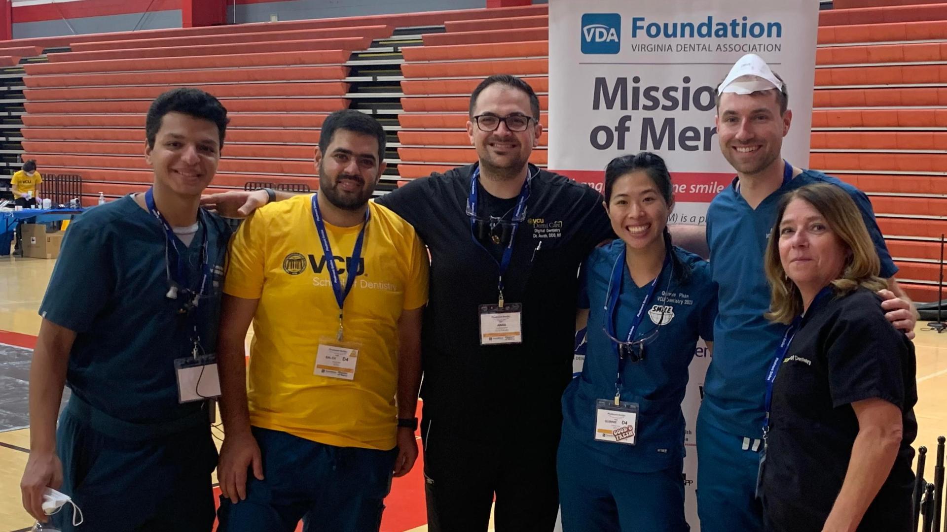 Phan (third right) and Adzima (second right) volunteered for Missions of Mercy projects under the leadership of Michelle McGregor (far right).